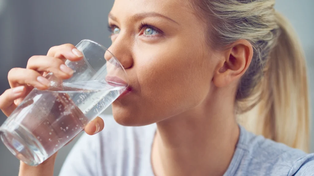 benefici magnesio e potassio, ragazza beve un bicchiere d'acqua